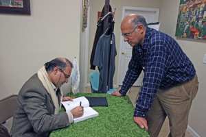 Karim El Koussa signs a copy of "Jesus the Phoenician" for a patron